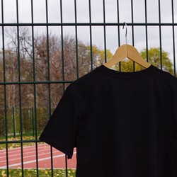 Foto der Rückseite des schwarzen T-Shirts am Sportplatz